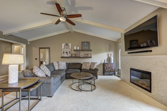 living room featuring carpet flooring, a ceiling fan, lofted ceiling with beams, and a fireplace