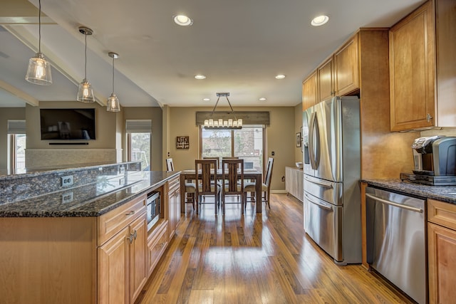 kitchen featuring wood-type flooring, recessed lighting, appliances with stainless steel finishes, and brown cabinets