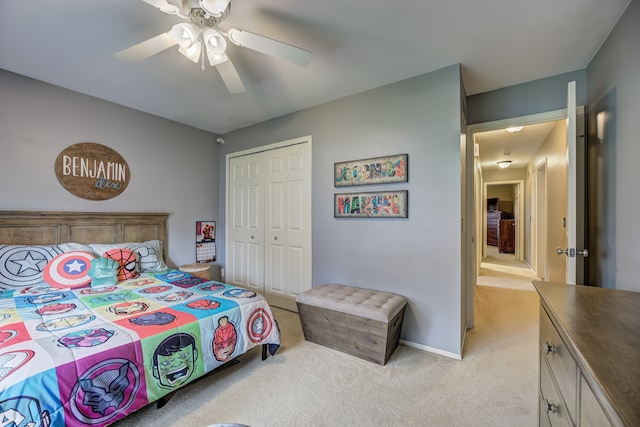 bedroom featuring ceiling fan, light carpet, baseboards, and a closet