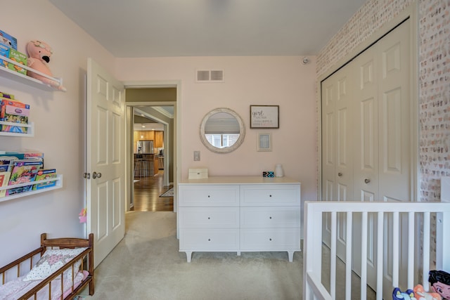 bedroom with visible vents, light carpet, and a closet
