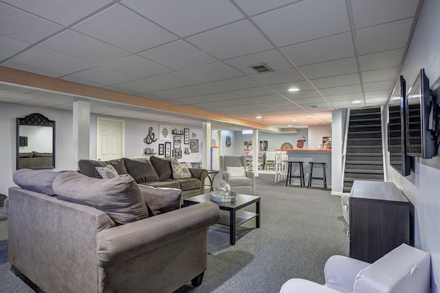 living area with carpet floors, a paneled ceiling, visible vents, bar area, and stairway
