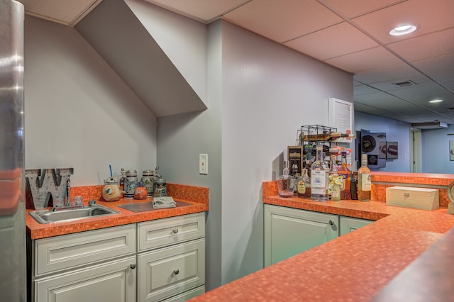 bar featuring visible vents, indoor wet bar, a drop ceiling, recessed lighting, and a sink