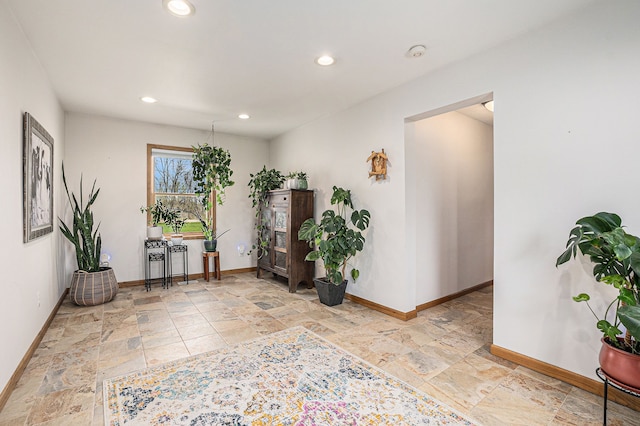 interior space featuring stone tile floors, recessed lighting, and baseboards