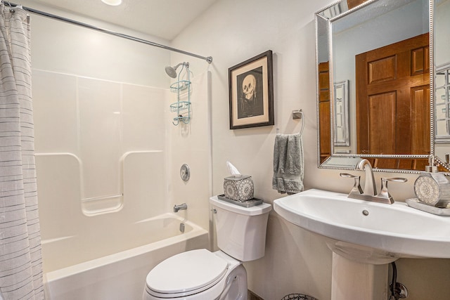 bathroom with toilet, a sink, and shower / bath combo with shower curtain