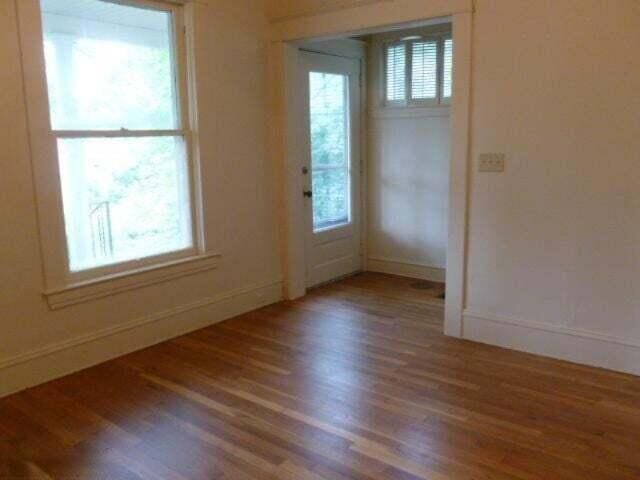 empty room featuring wood finished floors and baseboards