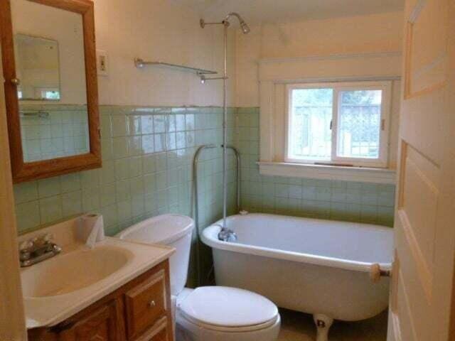 bathroom with tile walls, vanity, a tub, toilet, and a shower