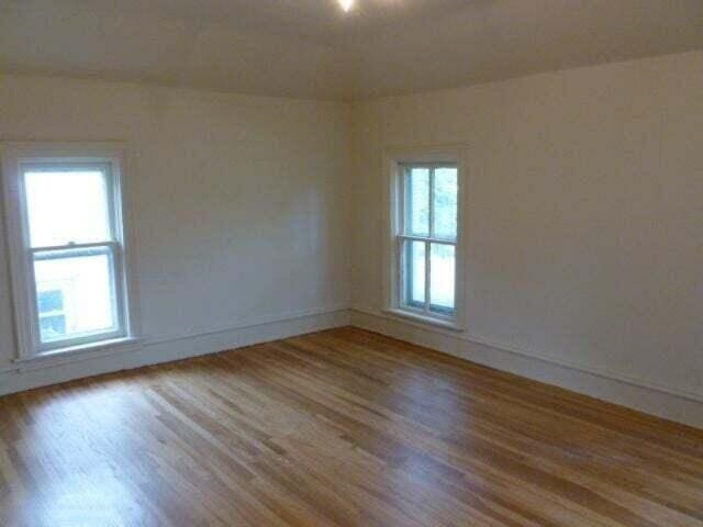 unfurnished room with baseboards and wood finished floors
