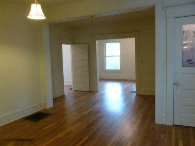 spare room featuring visible vents, wood finished floors, and baseboards