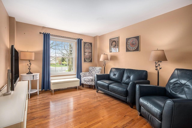 living area featuring light wood finished floors and baseboards