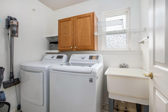 laundry area with a sink, separate washer and dryer, and cabinet space