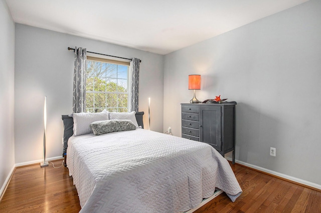 bedroom with baseboards and wood finished floors
