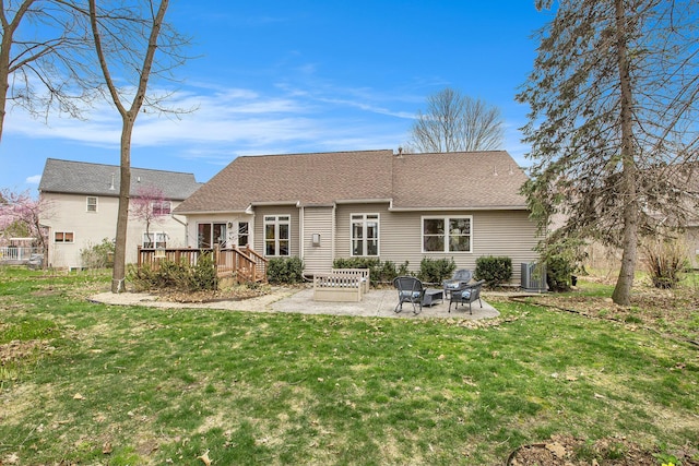 rear view of house featuring a lawn, a shingled roof, a patio, and a wooden deck