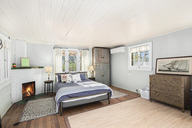 350 Ferry St, Douglas, MI 49406 - bedroom featuring a fireplace, hardwood / wood-style flooring, a wall mounted AC, and multiple windows