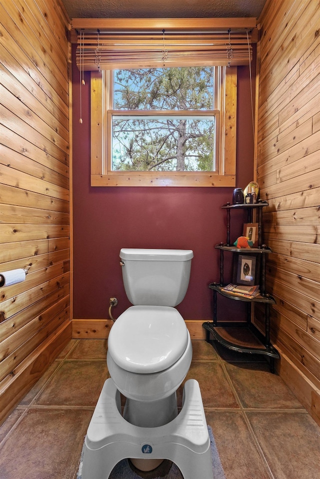 320 Marble St, Cadillac, MI 49601 - bathroom featuring tile patterned floors, toilet, and wood walls