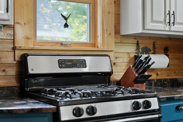 320 Marble St, Cadillac, MI 49601 - kitchen with stainless steel gas range, dark countertops, and white cabinets