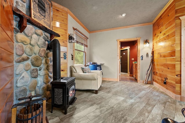 320 Marble St, Cadillac, MI 49601 - sitting room with crown molding, a wood stove, wood finished floors, baseboards, and a textured ceiling