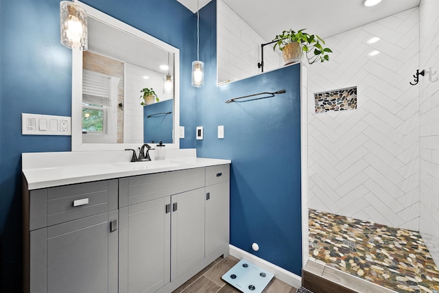320 Marble St, Cadillac, MI 49601 - bathroom featuring vanity, baseboards, walk in shower, and wood finished floors