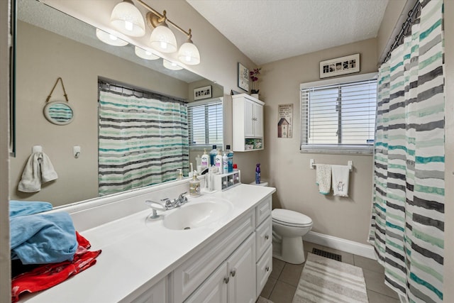 bathroom featuring a textured ceiling, visible vents, plenty of natural light, and tile patterned flooring