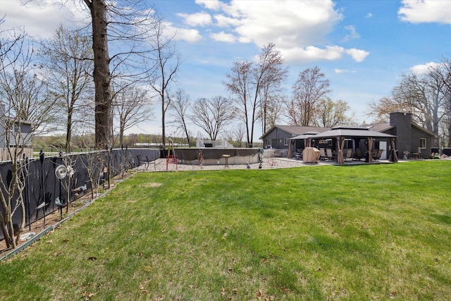 view of yard featuring fence, a fenced in pool, a gazebo, and a patio area