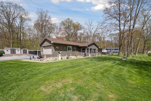 rear view of house with a storage unit, board and batten siding, a yard, and driveway
