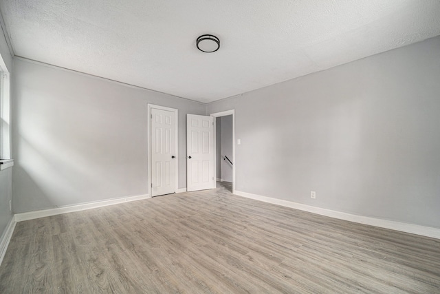 16140 Monte Vista St, Detroit, MI 48221 - empty room featuring light wood-type flooring, baseboards, and a textured ceiling