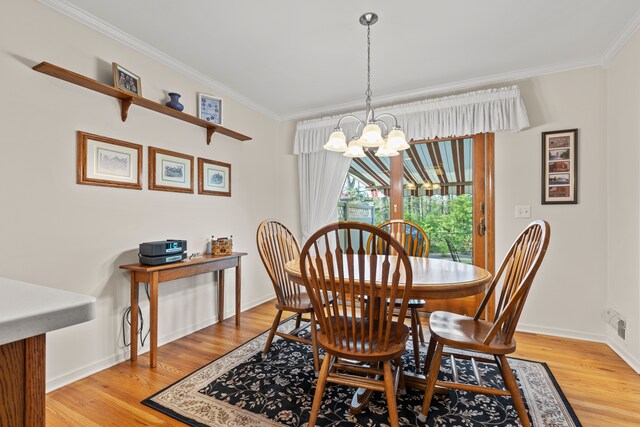dining room with crown molding, baseboards, a chandelier, and light wood-type flooring