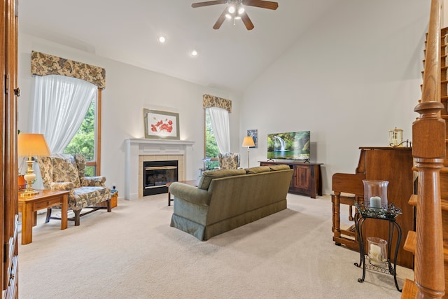 living room with plenty of natural light, ceiling fan, light carpet, and high vaulted ceiling