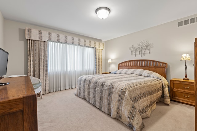 bedroom featuring light colored carpet and visible vents