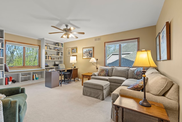 living room featuring carpet flooring, ceiling fan, and visible vents
