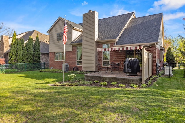 back of property with a fenced backyard, roof with shingles, a chimney, brick siding, and a lawn