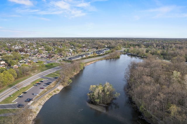 birds eye view of property featuring a water view and a wooded view