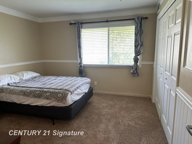 carpeted bedroom featuring baseboards and a closet