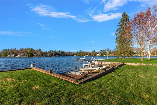 view of dock with a water view and a yard