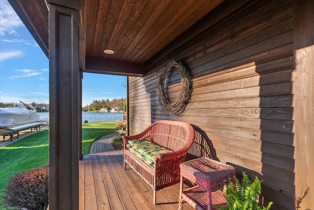 wooden terrace with a lawn and a water view