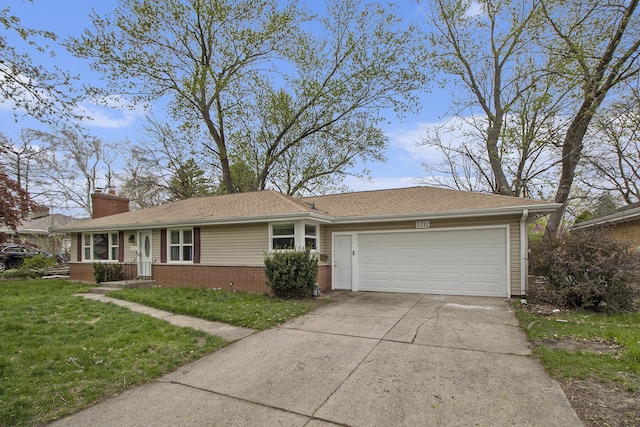 view of front of house with a garage, a front lawn, a chimney, brick siding, and concrete driveway