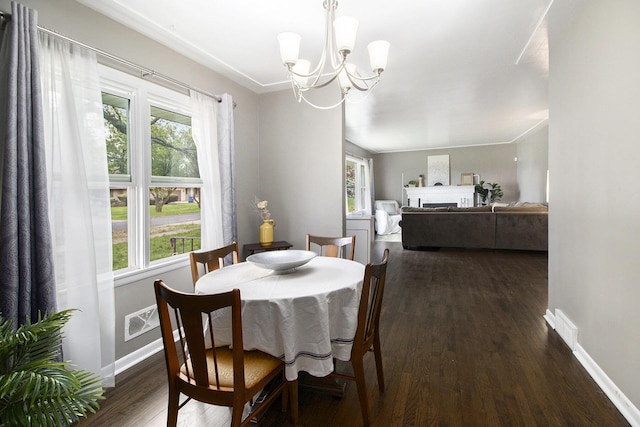 dining space featuring an inviting chandelier, dark wood-type flooring, and a healthy amount of sunlight