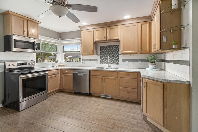 kitchen with visible vents, a ceiling fan, tasteful backsplash, a sink, and stainless steel appliances