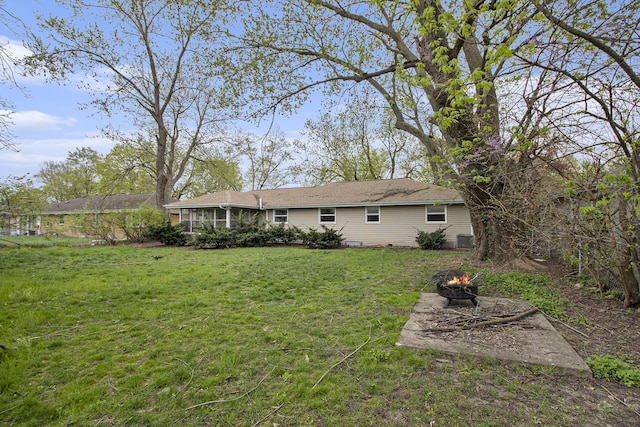 view of yard with a sunroom, a fire pit, and cooling unit
