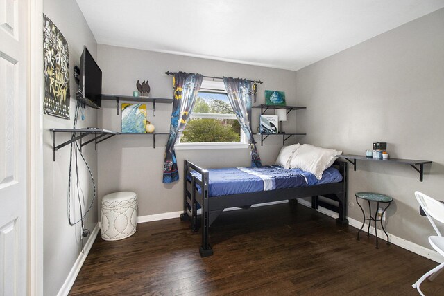 bedroom featuring baseboards and wood finished floors
