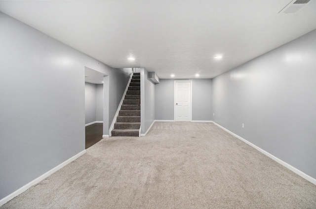 finished basement with visible vents, stairs, baseboards, recessed lighting, and carpet