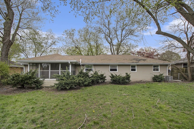 back of property featuring a yard, fence, and a sunroom