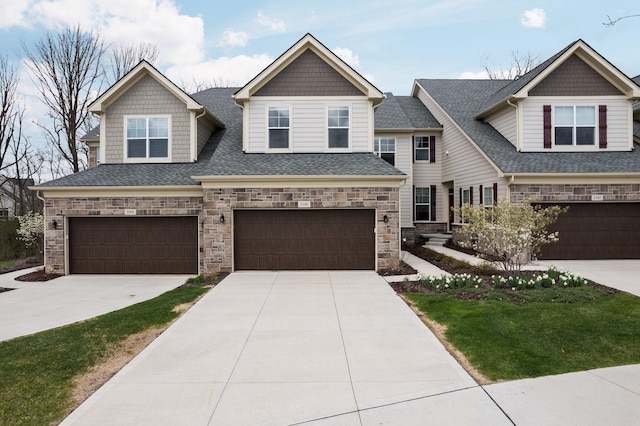 view of front of home featuring stone siding, concrete driveway, and a garage