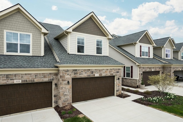 craftsman-style home featuring driveway, stone siding, an attached garage, and roof with shingles