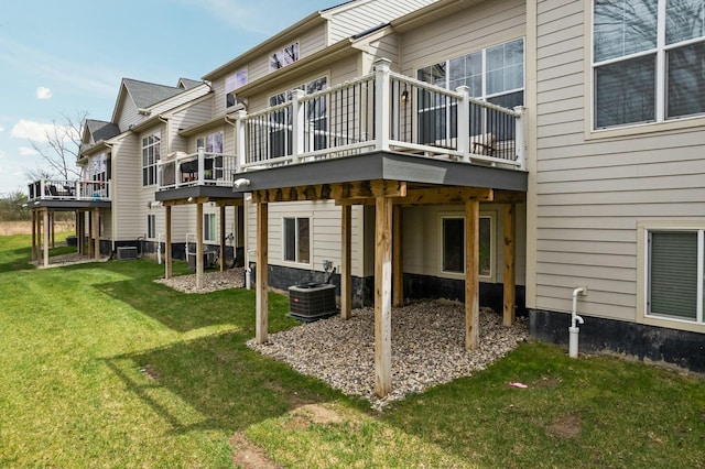 rear view of house with a deck, a yard, and central air condition unit