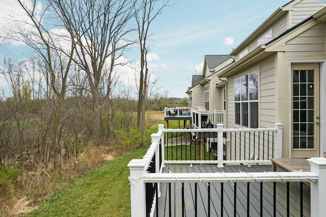 wooden deck featuring a lawn