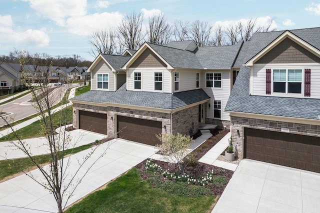 view of front of home featuring stone siding, roof with shingles, concrete driveway, and a garage