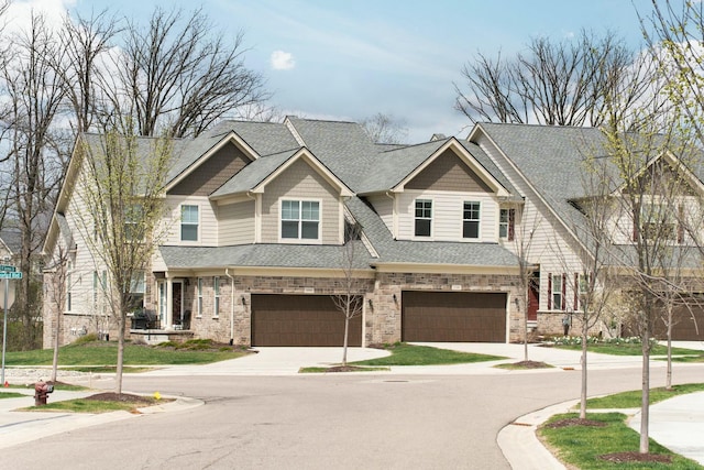 craftsman-style home with concrete driveway, a shingled roof, and a garage