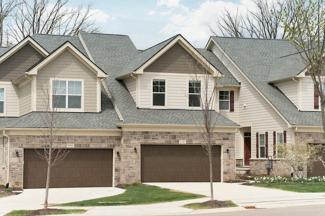 view of front of house with concrete driveway, stone siding, a garage, and roof with shingles