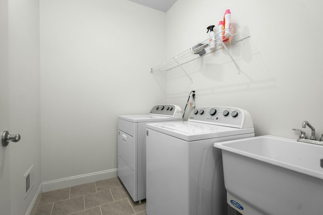 laundry room featuring a sink, washer and clothes dryer, light tile patterned flooring, laundry area, and baseboards