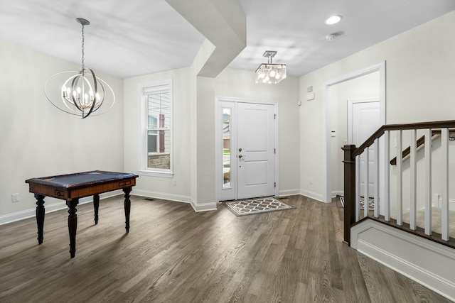 foyer featuring baseboards, an inviting chandelier, stairway, and dark wood finished floors